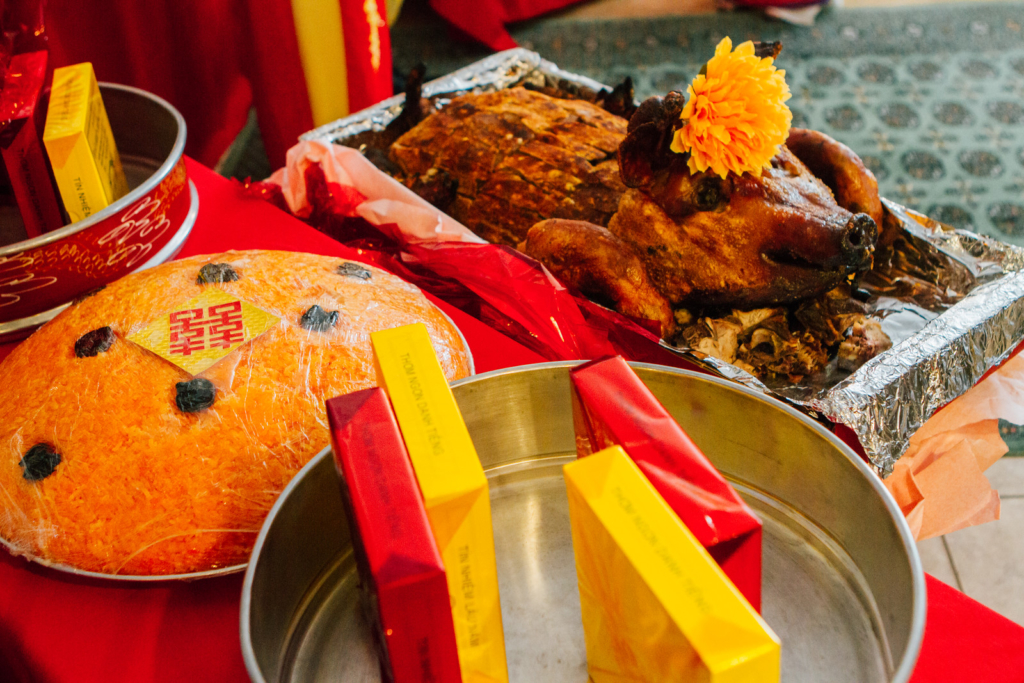 A roasted pig on a table along rice and pastries 