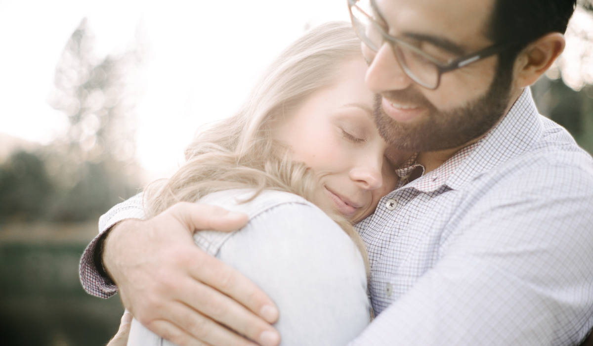 Couple lovingly embrace during sunset